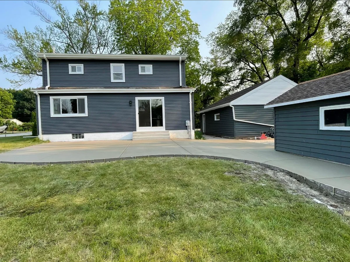 Curved concrete patio poured behind a two-story home