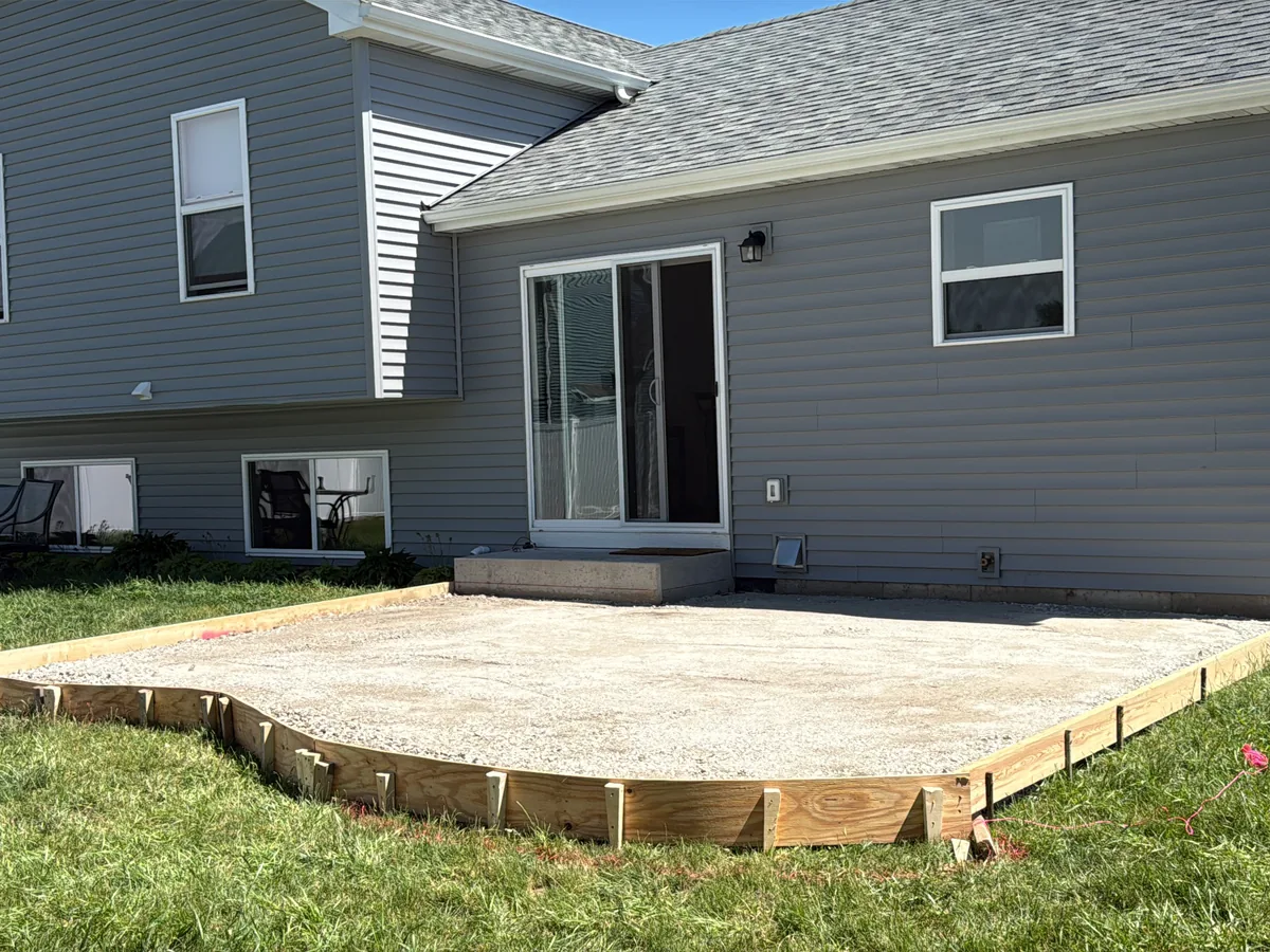 Compacted gravel patio base set inside wood forms