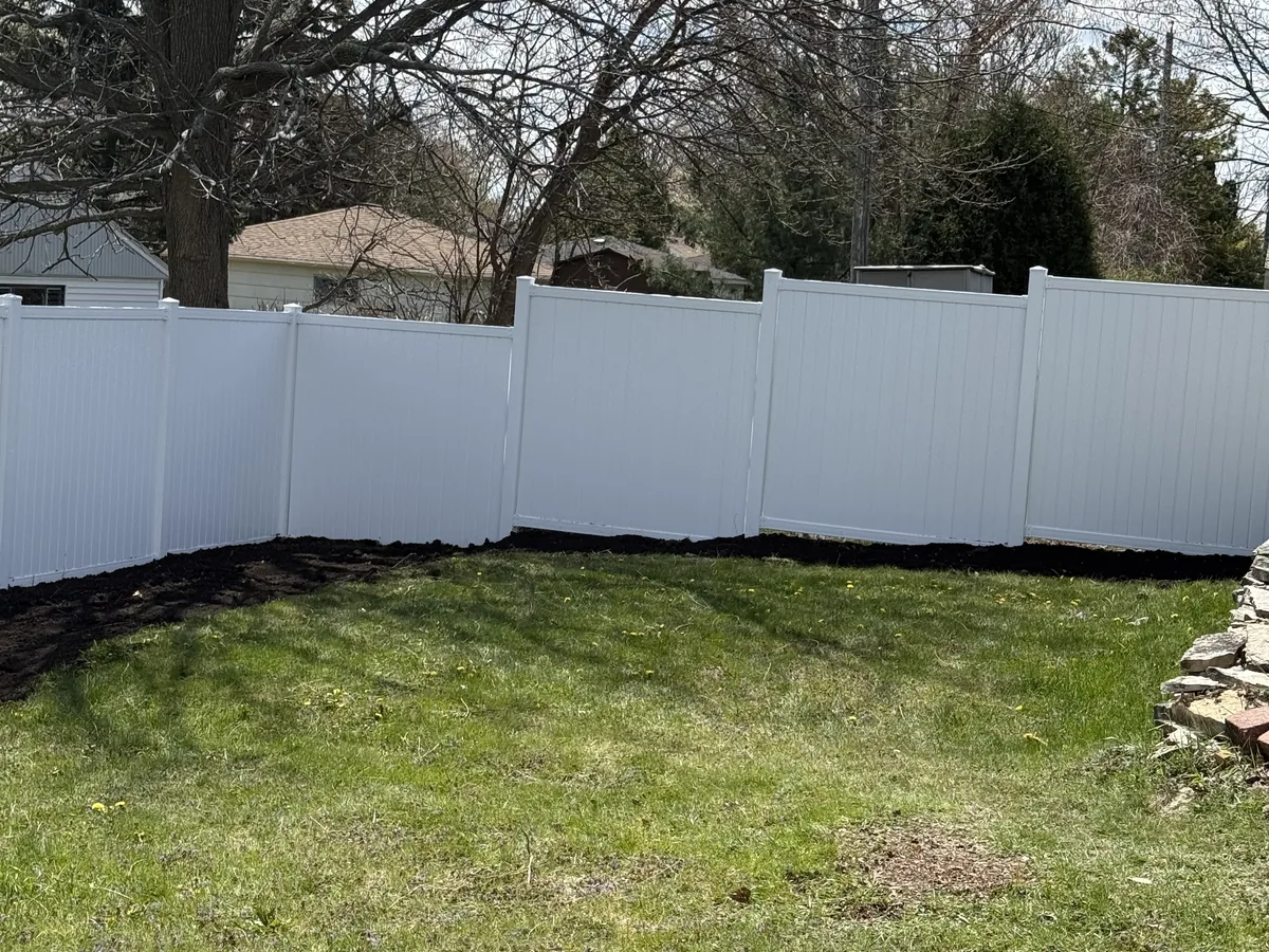 White vinyl privacy fence enclosing a backyard