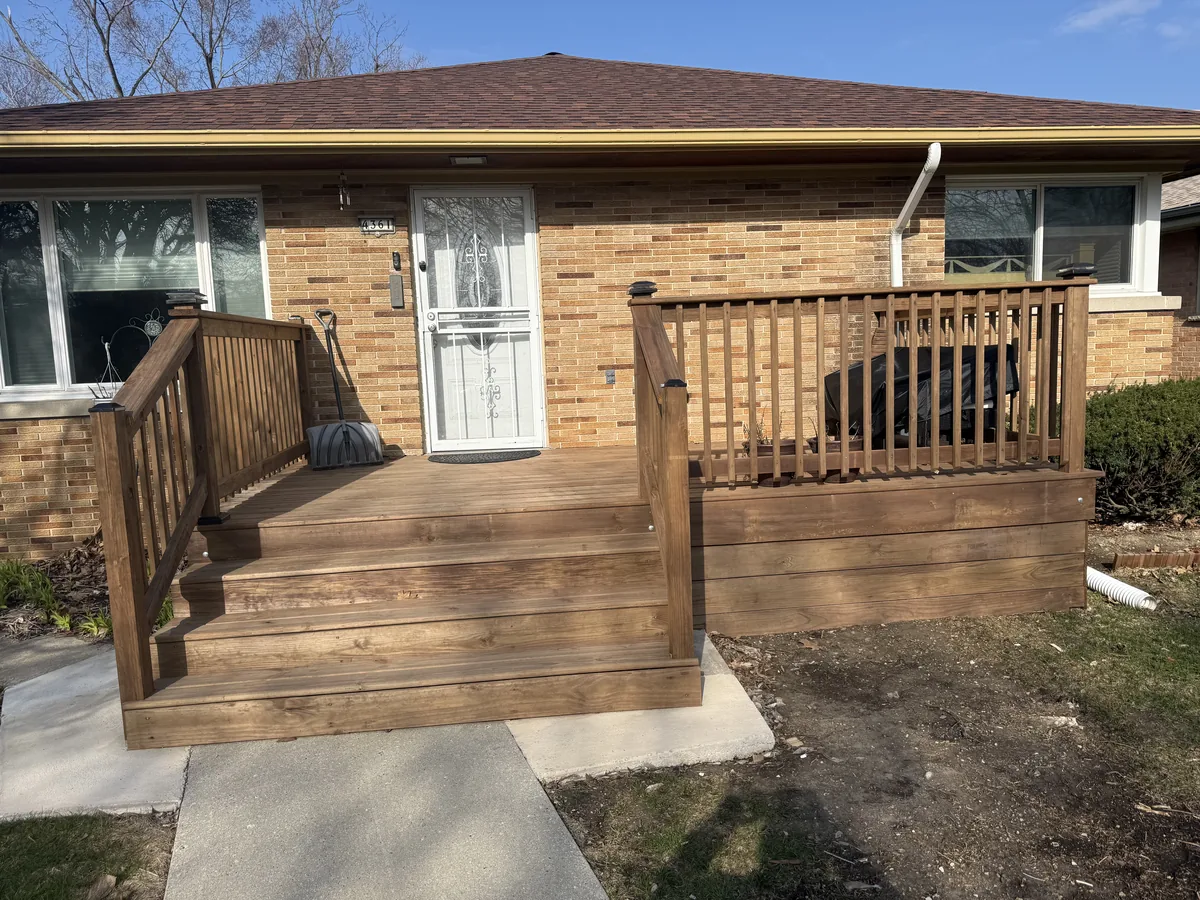 Stained wood front porch with stairs and railings